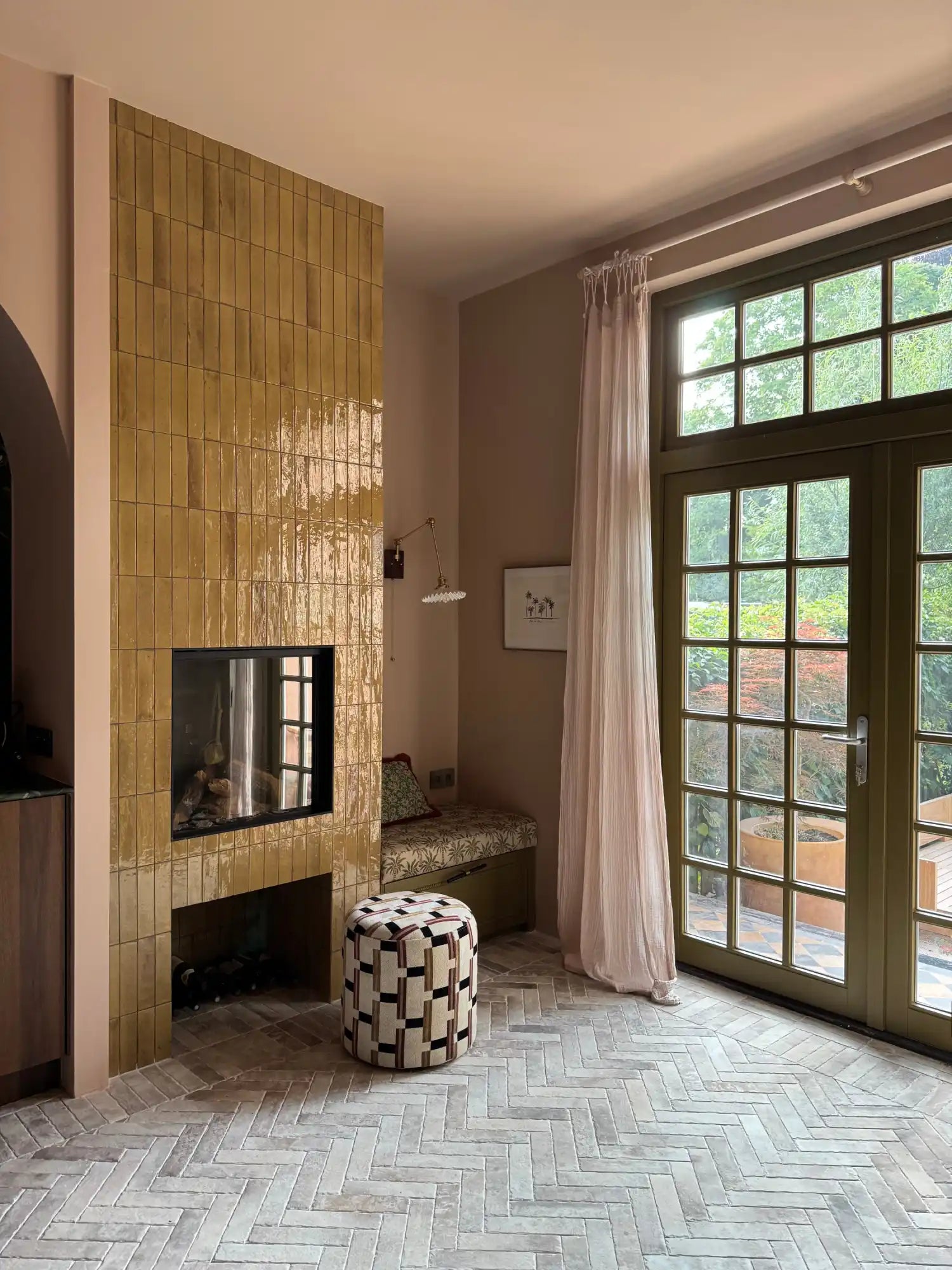 Goud mozaïek tegel open haard met zwarte glazen voorzijde en modern ontwerp.