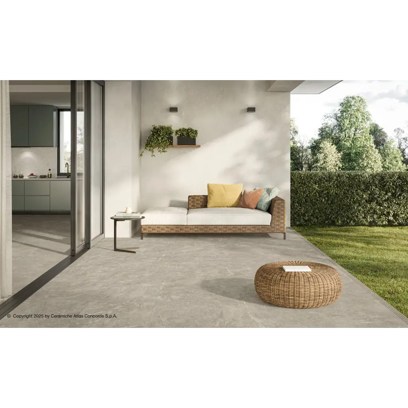 Rattan buitenbed met gele kussens en geweven poef op Duolith Fossil 60x60 vloer