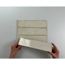 Witte keramische tegel Alchimia Ivory 7,5x30 in handen, perfect voor vloertegels