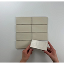 Witte keramische wandtegels van Atlas Vision Mate in een grid patroon, één wordt vastgehouden