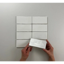 Witte rechthoekige papierstukken in grid met handen, Atlas White Brillo in beeld