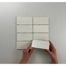 Witte rechthoekige kaarten in een rooster met een hand die de Atlas White Mate tilt