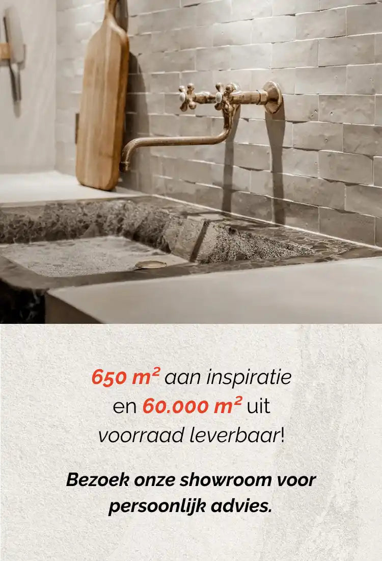 Betonnen gootsteen met een messing industriële stijl kraan bevestigd aan een witte bakstenen muur.