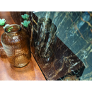 Een amberkleurige geribbelde glazen pot op een houten tafel met black golden pulido 60x120 rett textuur