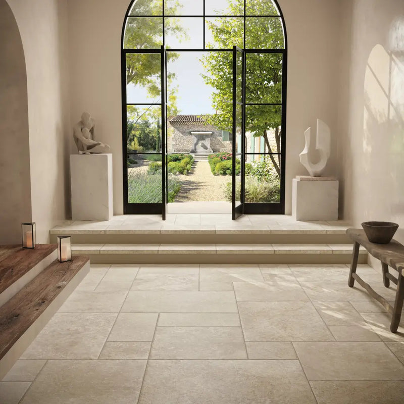 Arched glass door opening to garden view with Chantilly Creme 30x30 chip tile design