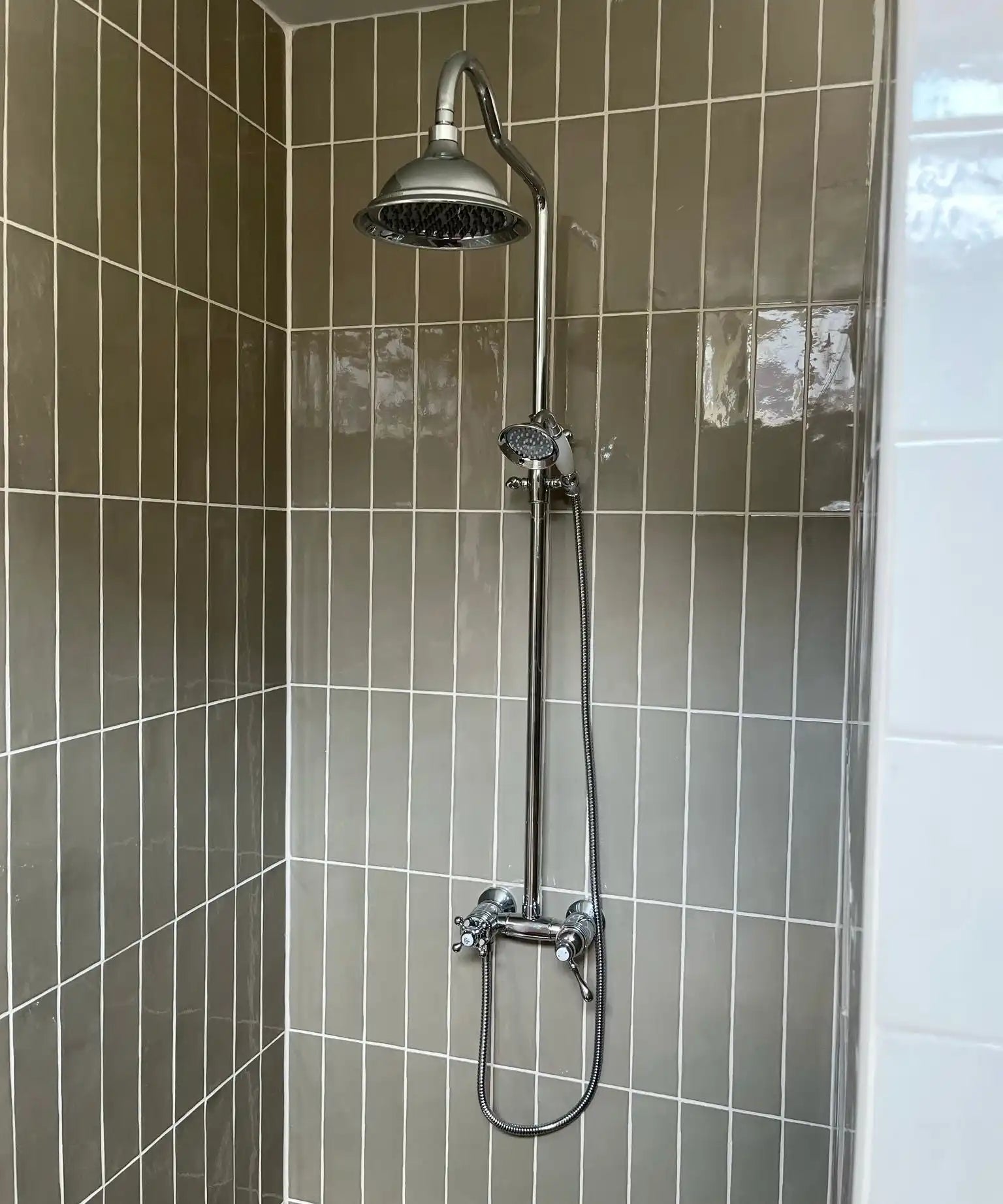 Chrome douchekop met slang en handdouche, modern ontwerp.