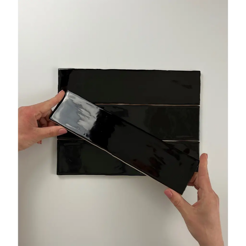 Zwarte glanzende Colonial Black glans 7,5x30 panelen worden van elkaar getrokken