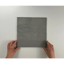 Vrouwelijke handen houden vier gestapelde koloniale grijze glanspanelen vast