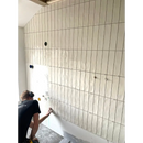 Witte verticale subway tegels worden geplaatst op een muur met Colonial Ivory Glans