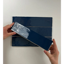 Navy blue paint swatch card being peeled, showcasing Colonial Marine Glans kleur