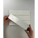 Witte papierstrook horizontaal boven een geruite ondergrond bij Colonial White mat 7,5x30