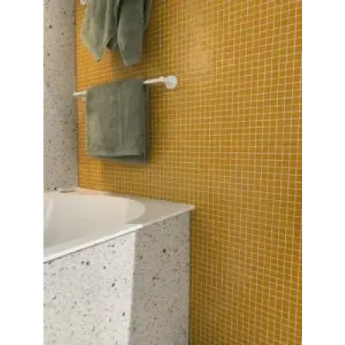 Witte badkuip met speckled grijze surround in GM41 Orange Soft Grain wandtegels