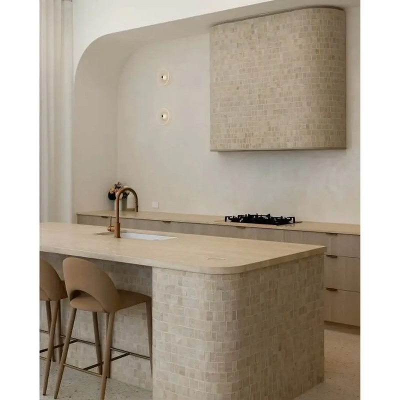 Beige marmeren keuken eiland Hazel Travertin met gebogen barkrukken en moderne kraan