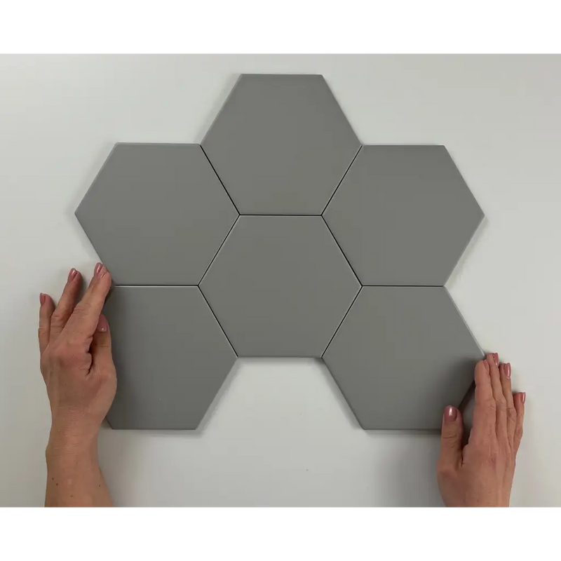 Zes grijze hexagonale tegels in een honingraatpatroon op Hexagon Timeless Grey mat 15x17