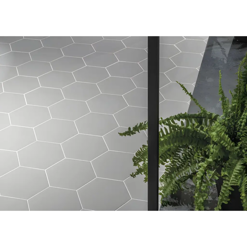 Witte hexagonale tegels in een herhalend patroon op de Hexagon Timeless Grey mat 15x17