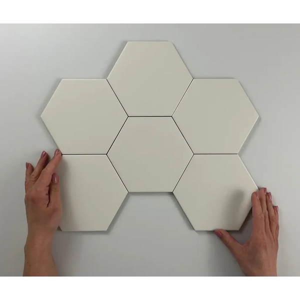 Zes witte hexagonale tegels in honingraatpatroon op de Hexagon Timeless Ivory mat 15x17