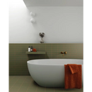 Moderne vrijstaande ovale badkuip met een burnt orange handdoek en Kalma Selva 6x18 mat