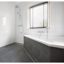 Witte badkamer met Kerabo wit glans en donkergrijze panelen tegen de muur