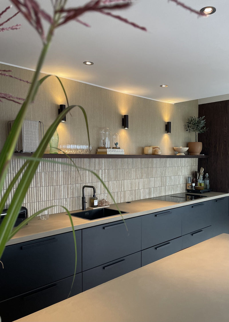 Moderne keuken met Lulu Travertin vloertegels, donkere kasten en lichte werkbladen