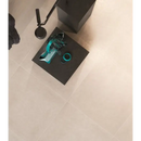 Turquoise ring shines on dark surface with Maku Sand 60x60 Rett tiles backdrop