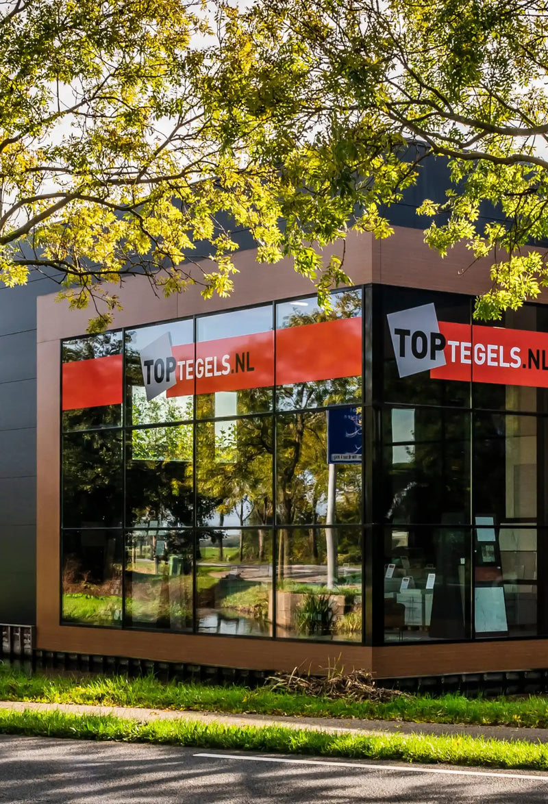 Modern kantoorgebouw met 'Top Rebels' signage en reflecterende glazen ramen.