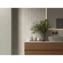 A tall gray ceramic vase with lush green foliage in mytos bone neli decor 60x120 design