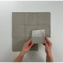 Vierkante grijze keramische Oud Hollandse Witjes 13x13 op een oppervlak gelegd