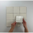 Witte keramische tegels in grid met hand die witjes Ivoor 13x13 vasthoudt