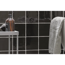 Bruine glazen fles op een badkamerplank met Oud Hollandse Witjes Zwart 13x13