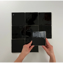 Zwarte glossy keramische tegels in een grid met handen die een witje zwart 13x13 plaatsen