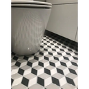 Witte porseleinen toiletbasis op PACUMIX1 glossy vloertegels met geometrisch patroon