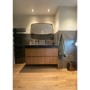 Moderne floating vanity met Padouk Nut 30x120 onder ovale spiegel en zwartblad.Countertop