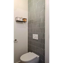 Witte porseleinen toilet tegen een geometrische muur met PAPIC82 groen grijs