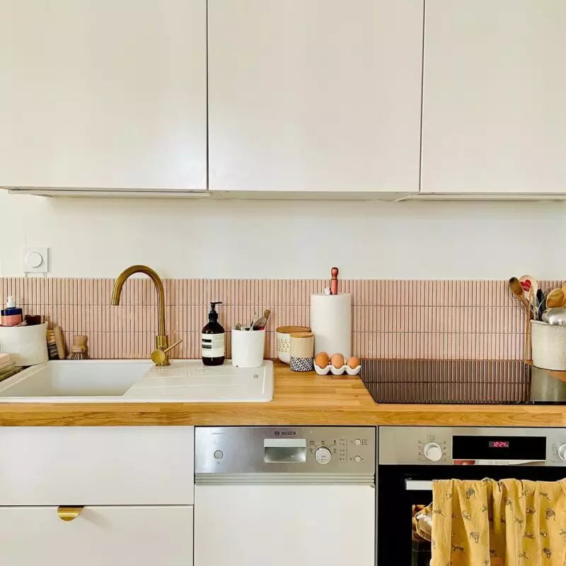 Moderne witte keuken met houten aanrecht en roze glossy tegels achterwand