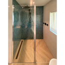 Moderne inloopdouche met azuurblauwe glanzende sepcle en glazen deur