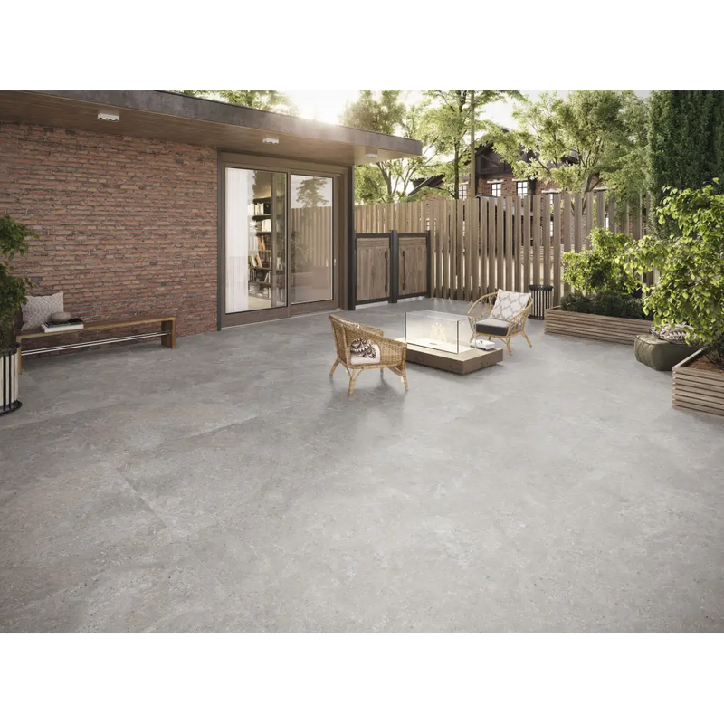 Grijze betonpatio met loungestoelen en Stoneland Grey mat 80x80 rett erop