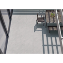 Houten patiostoel in schaduw op lichtgekleurde vloer met Terrastegel Kliff Pearl 60x60