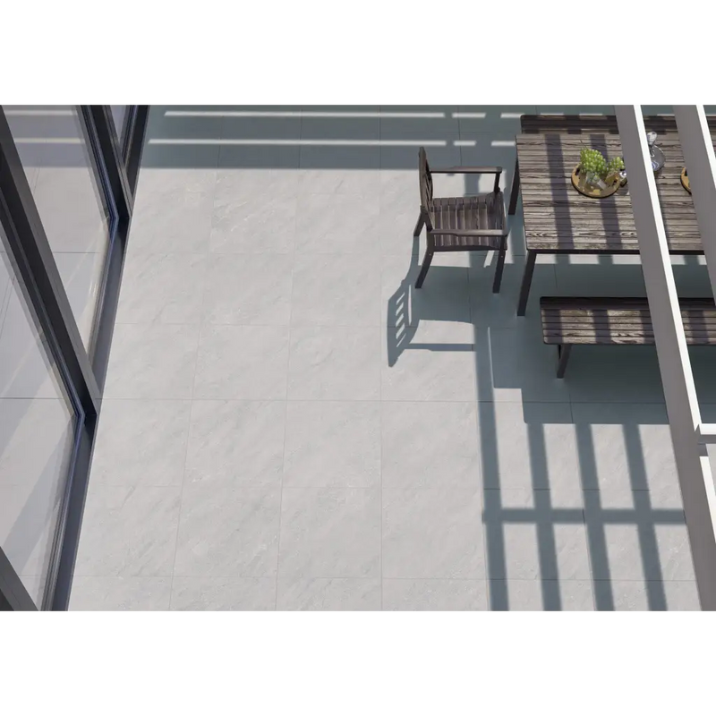 Houten patiostoel in schaduw op lichtgekleurde vloer met Terrastegel Kliff Pearl 60x60