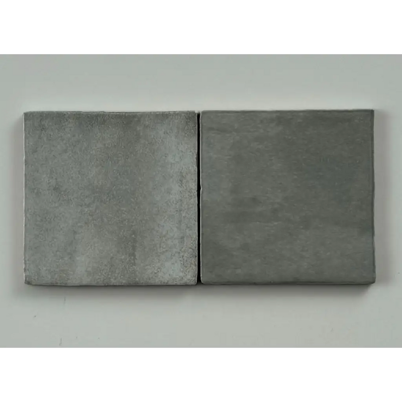 Twee matte grijze tegels met subtiele structuur van trend tegels grijs glans 10x10 voor een stijlvolle afwerking
