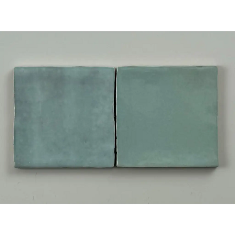 Twee matte teal keramische trend tegels licht met licht blauw glans 10x10 en iets ongelijke randen naast elkaar