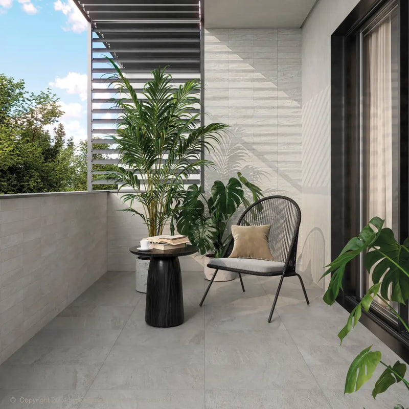 Moderne balkon met Ultrablock Silver 30x60, zwarte wire stoel en tropische planten