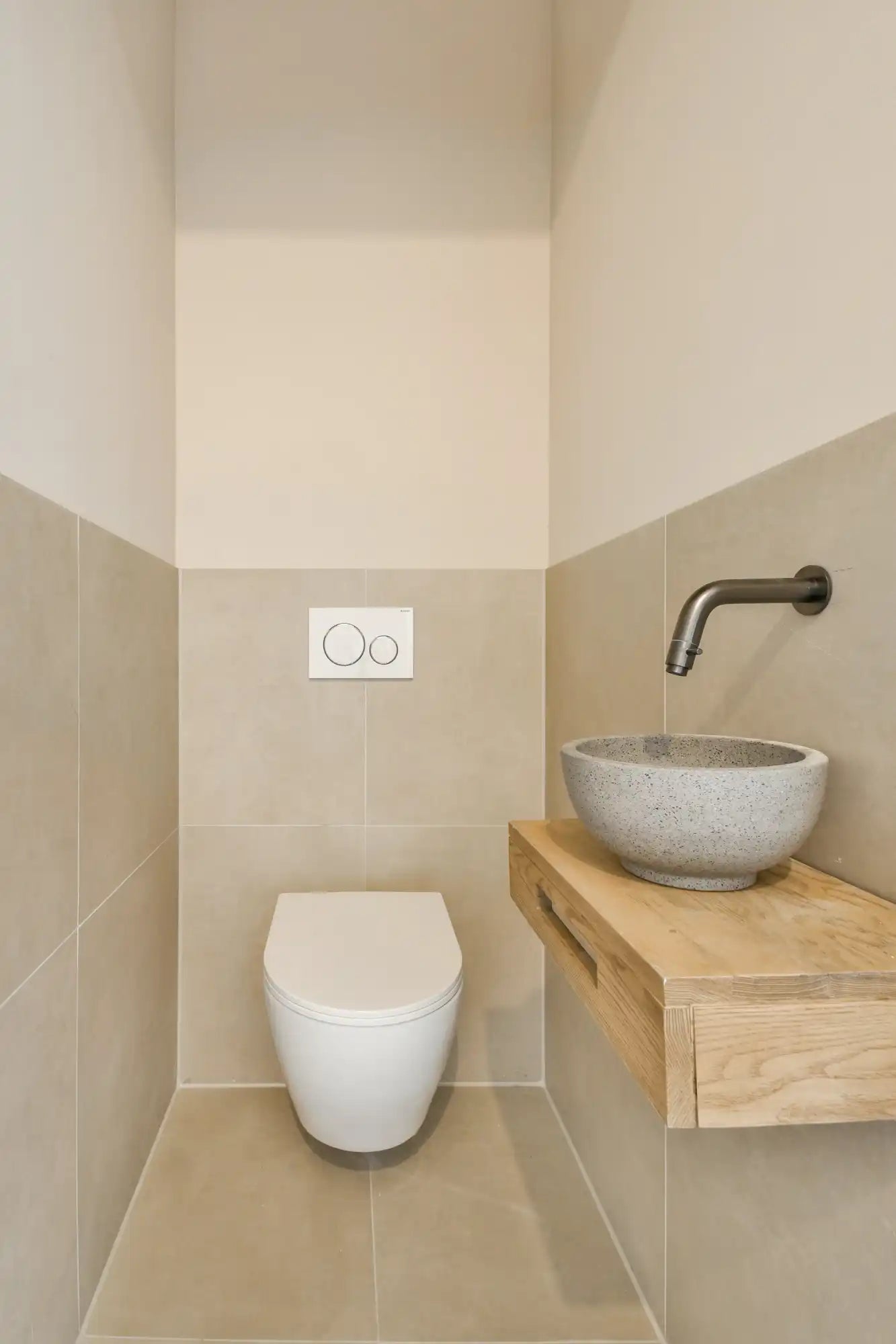 Witte keramische toilet met modern ontwerp en houten aanrechtblad.