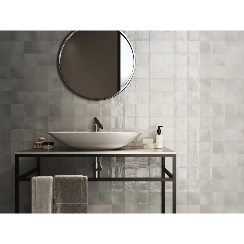 Oval vessel sink on a black metal vanity with glass shelf and Zellige Grey 10x10 tile