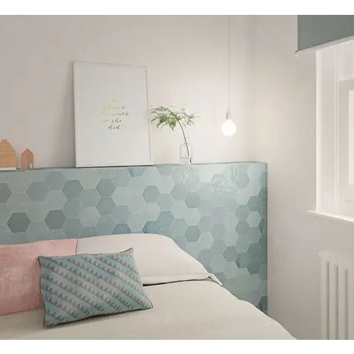 Bed met mintgroene hexagonale hoofdbord en kussens van Zellige Hexa Aqua