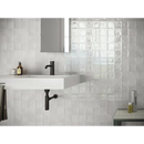 Witte wandgoot met matte zwarte kraan, perfect voor Zellige White 10x10 stijl