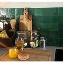 Houten snijplank met sinaasappelsap en bagel op Zelliges Alhambra 03 Cypresse 10x10 cm