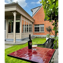 Fles wijn en glas op een rode tegeltafel met Zelliges Alhambra 04 Rouge Medaillon 10x10 cm