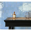 Glazen whiskeyfles met metalen dop op een donkere ondergrond naast Zelliges Alhambra Lavande 10x10cm