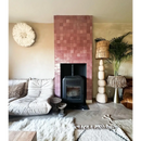 Zwart houtkachel met een roze tegelwand van Zelliges Alhambra Vieux Rose 10x10 cm