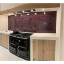 Zwart dual-fuel fornuis met meerdere branders en ovens bij Zelliges Alhambra Aubergine